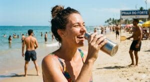 pessoa-bebendo-agua-na-praia